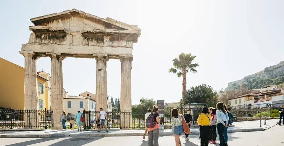 Grupo de turistas explorando el antiguo Templo de Hefesto en Atenas, Grecia.