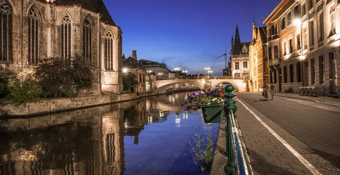 Urokliwy kanał w Brugii nocą, odbijający średniowieczną architekturę miasta.