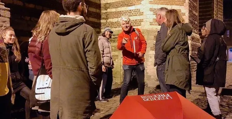 Un grupo de turistas en una visita guiada nocturna por Brujas.