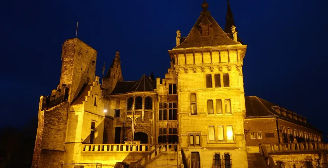 Zamek Gravensteen w Gandawie, Belgia, oświetlony w nocy.