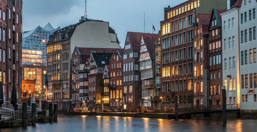 Histórica Speicherstadt de Hamburgo por la noche, edificios iluminados reflejados en el canal.