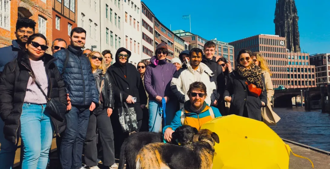 Feliz grupo turístico en Hamburgo, Alemania, disfrutando de un recorrido por la ciudad a lo largo del canal.