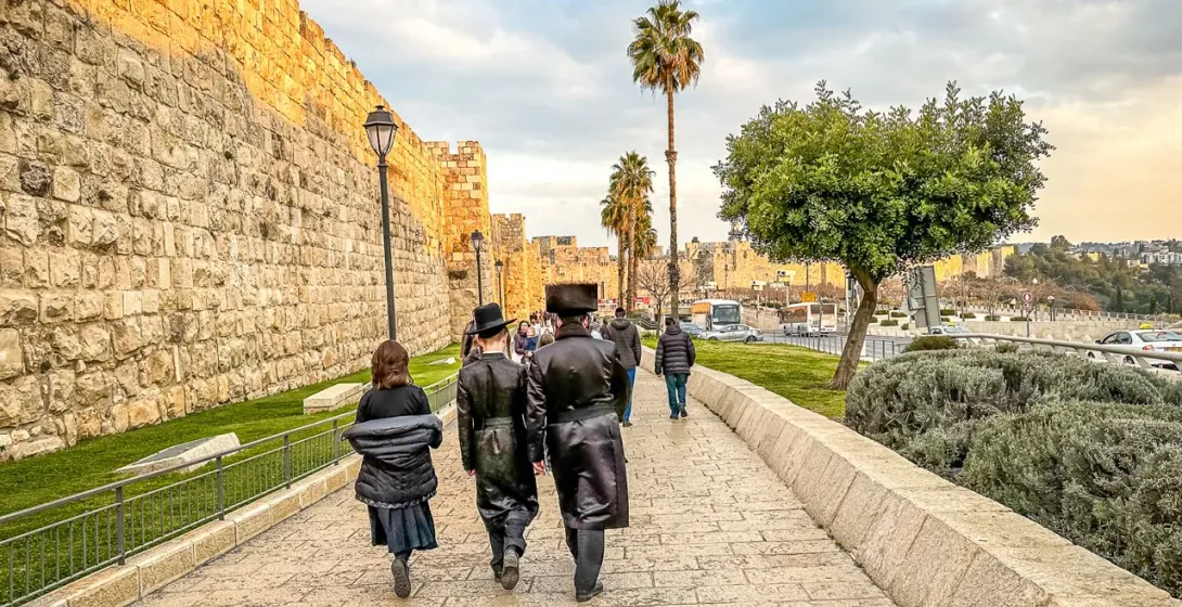 Turistas caminando a lo largo de las antiguas murallas de Jerusalén.