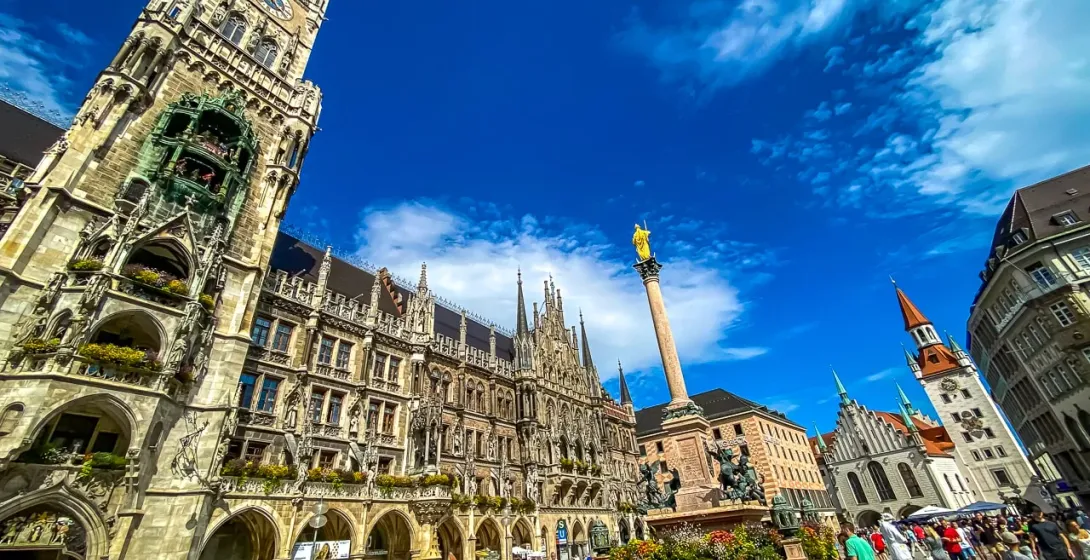 Turyści zwiedzają Marienplatz w Monachium, Niemcy, z nowym ratuszem w tle.