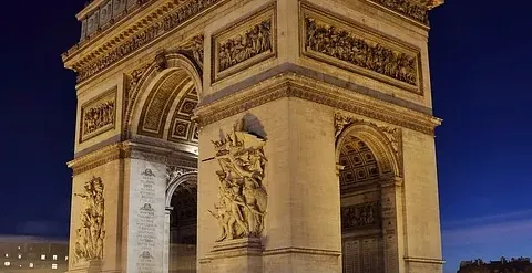 El Arco del Triunfo en París por la noche, bellamente iluminado.