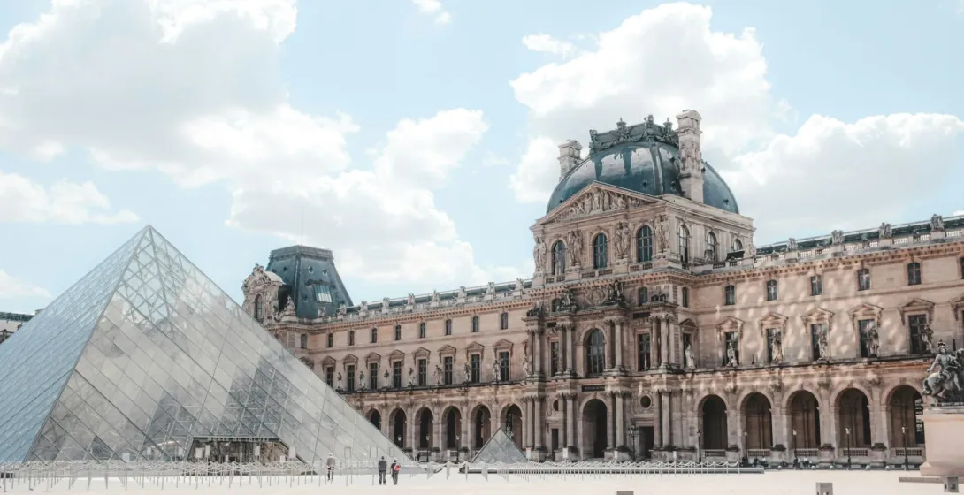 El Museo del Louvre en París, con su icónica pirámide de cristal y arquitectura clásica.