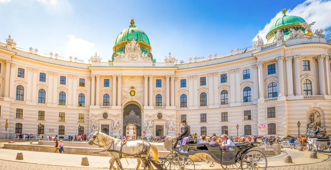 Turyści cieszą się przejażdżką powozem konnym przed Pałacem Hofburg w Wiedniu.