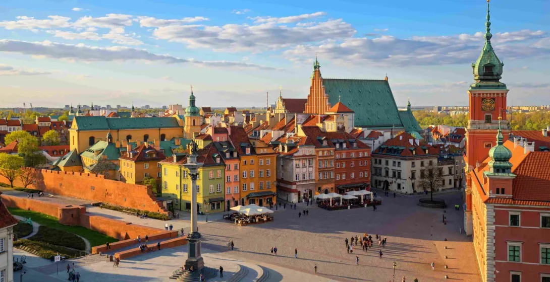 Panoramiczny widok na Rynek Starego Miasta w Warszawie o zachodzie słońca.