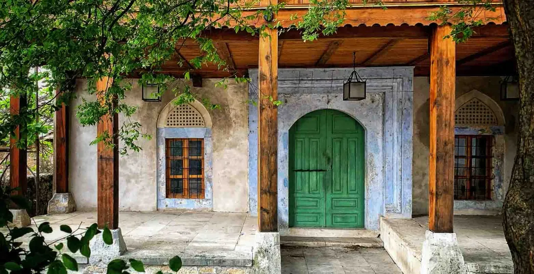 Spokojny wejście do historycznego budynku z zielonymi drzwiami.