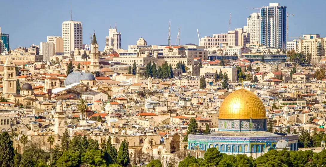 Blick auf Jerusalem mit dem goldenen Felsendom im Vordergrund und den Gebäuden der Altstadt und modernen Hochhäusern im Hinte