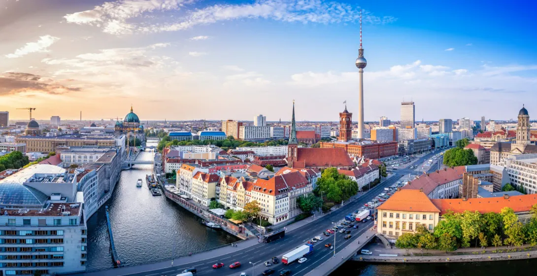 Panoramablick auf das Berliner Stadtzentrum mit dem Fernsehturm, dem Berliner Dom und der Spree bei Sonnenuntergang.