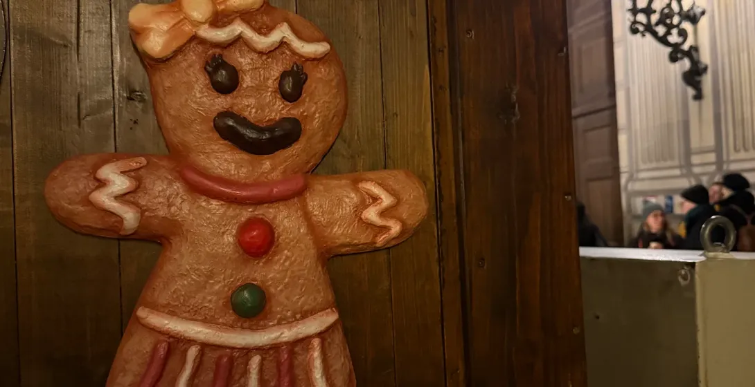 Lebkuchenfigur als Dekoration an einer Holzwand mit Tannenzweigen auf dem Münchner Weihnachtsmarkt.
