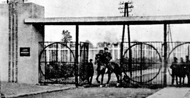 Puerta histórica con una figura a caballo.