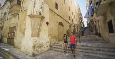 Pareja bajando escaleras en La Valeta, Malta.
