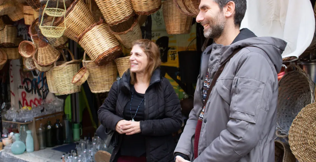 Una pareja feliz en una visita guiada por Atenas, admirando cestas tejidas tradicionales.