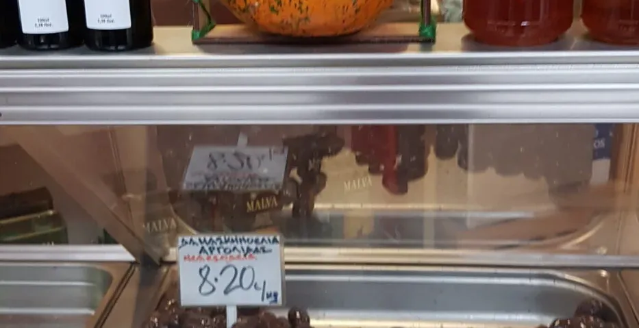 Una colorida exhibición de aceitunas, miel y aceite de oliva en un mercado griego.