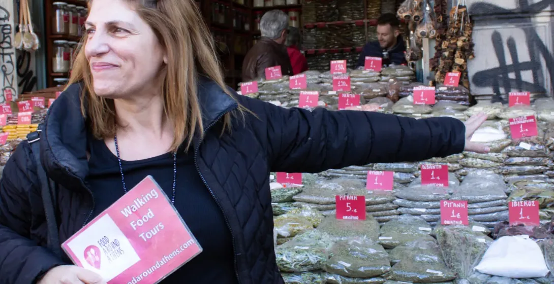 Una turista en un tour gastronómico en Atenas, Grecia, explora una vibrante tienda de especias.