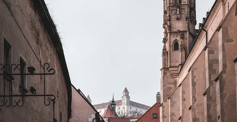 Calle empedrada en el casco antiguo de Bratislava con el Castillo de Bratislava al fondo.