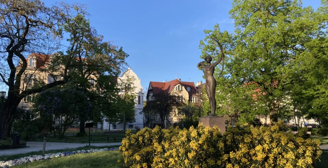 Brązowy posąg łuczniczki w parku w Dreźnie.