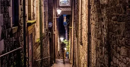 Encantador callejón empedrado en Edimburgo por la noche.