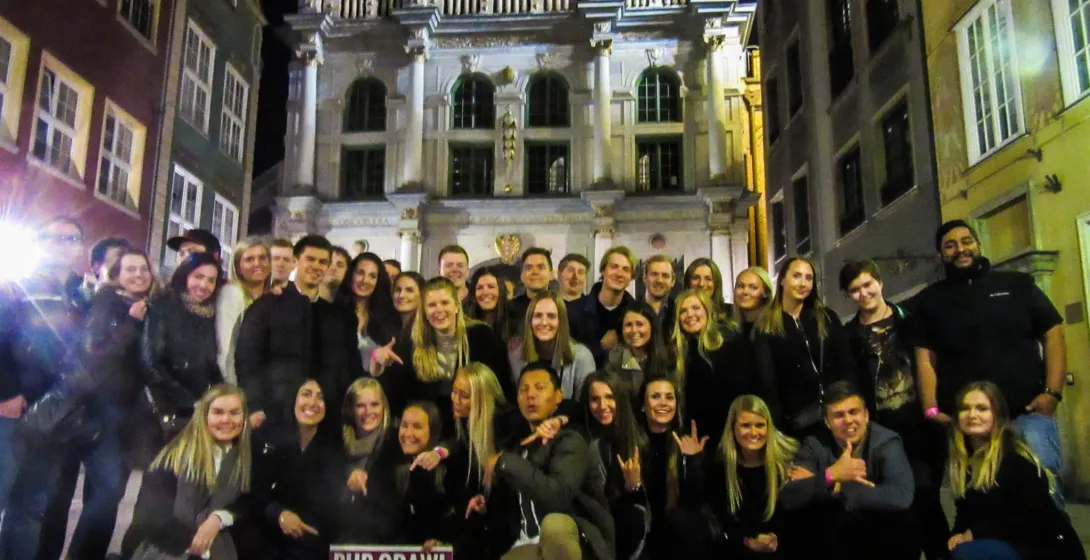 Wesoła grupa turystów na pub crawl w Gdańsku.