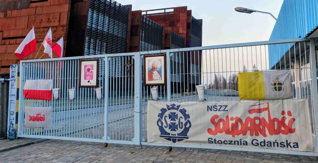 Brama Europejskiego Centrum Solidarności w Gdańsku, z banerami i flagami Solidarności.
