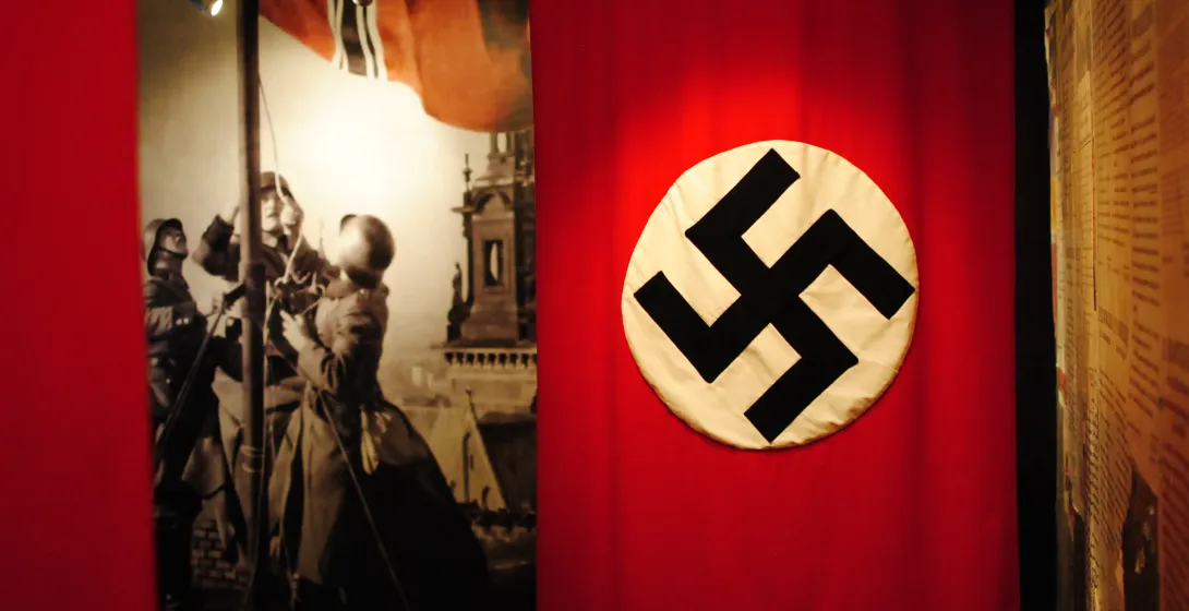 Museum exhibit showcasing a Nazi swastika flag and historical photographs.