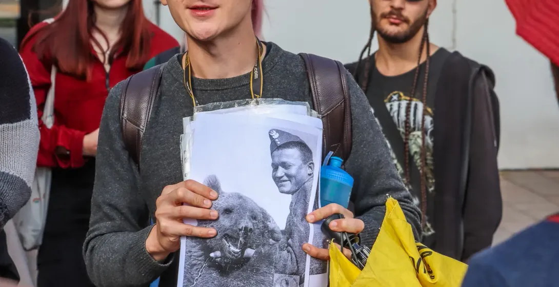 A tour guide in Germany shows a historical photo to a group.