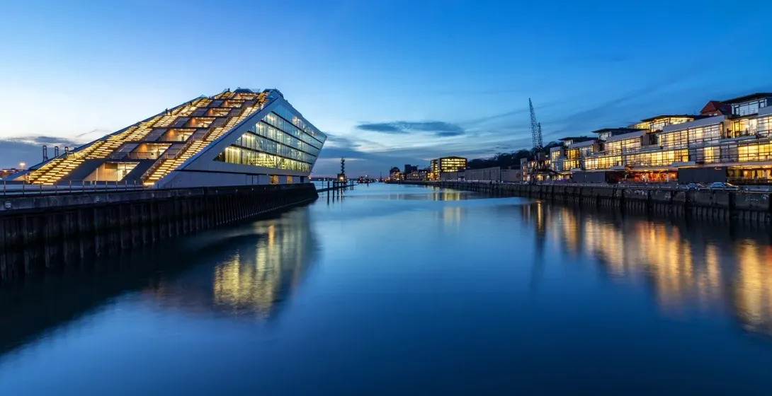 La Filarmónica del Elba en Hamburgo, Alemania, al atardecer, reflejándose en el puerto.