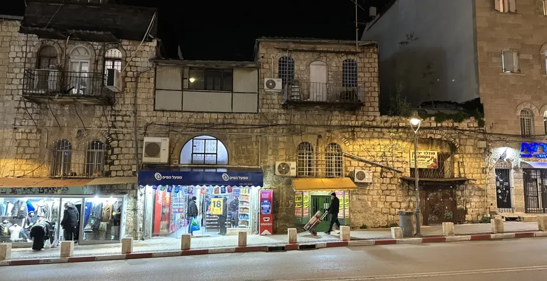Nachtszene in Jerusalems Altstadt mit historischen Steingebäuden und einer ruhigen Straße.