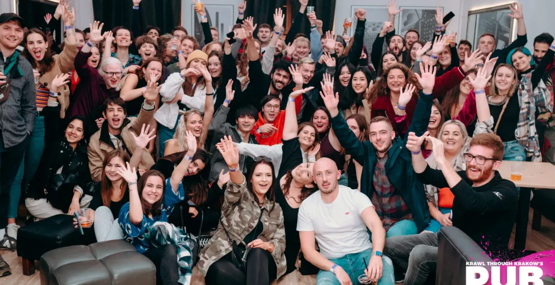 Weseli turyści bawiący się na pub crawl w Krakowie.