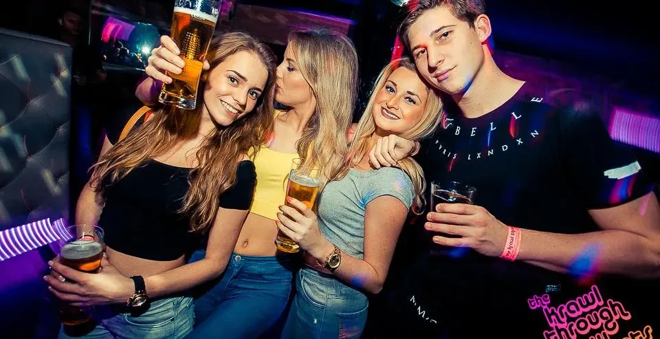 Grupa przyjaciół bawi się na pub crawl w Krakowie.