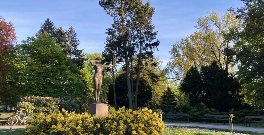 Brązowy posąg amazonki w krakowskim parku.