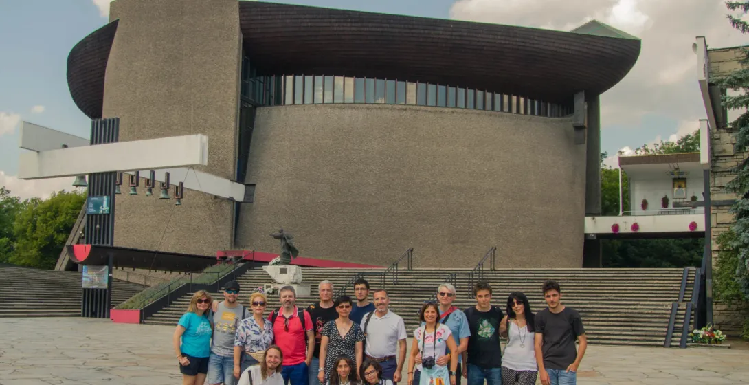 Eine fröhliche Reisegruppe posiert vor dem Heiligtum der Göttlichen Barmherzigkeit in Krakau, Polen.
