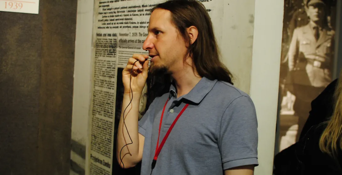 A tour guide leads a group through a Krakow museum, sharing historical insights.
