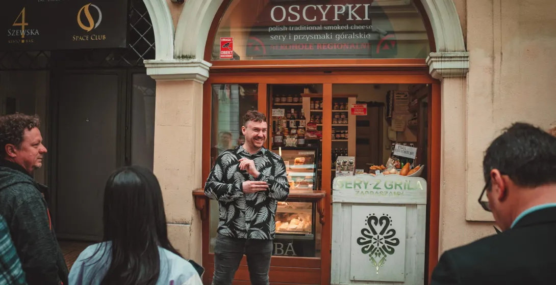 A food tour guide in Krakow, Poland, explains the local delicacy, Oscypek, to an enthusiastic group.