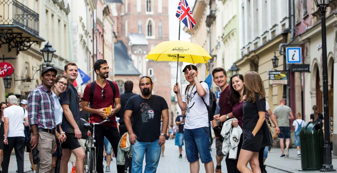 Happy tourists on a guided walking tour in Krakow's Old Town.