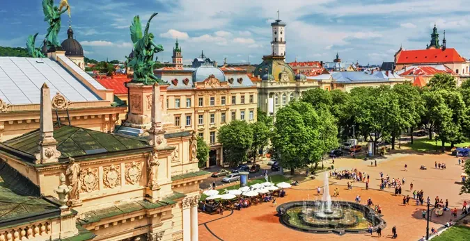 Turyści cieszą się słonecznym dniem na rynku w centrum Lwowa.