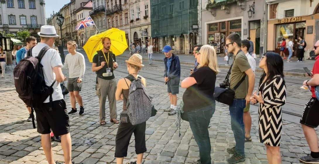 Przewodnik oprowadza grupę turystów po Lwowie na Ukrainie.