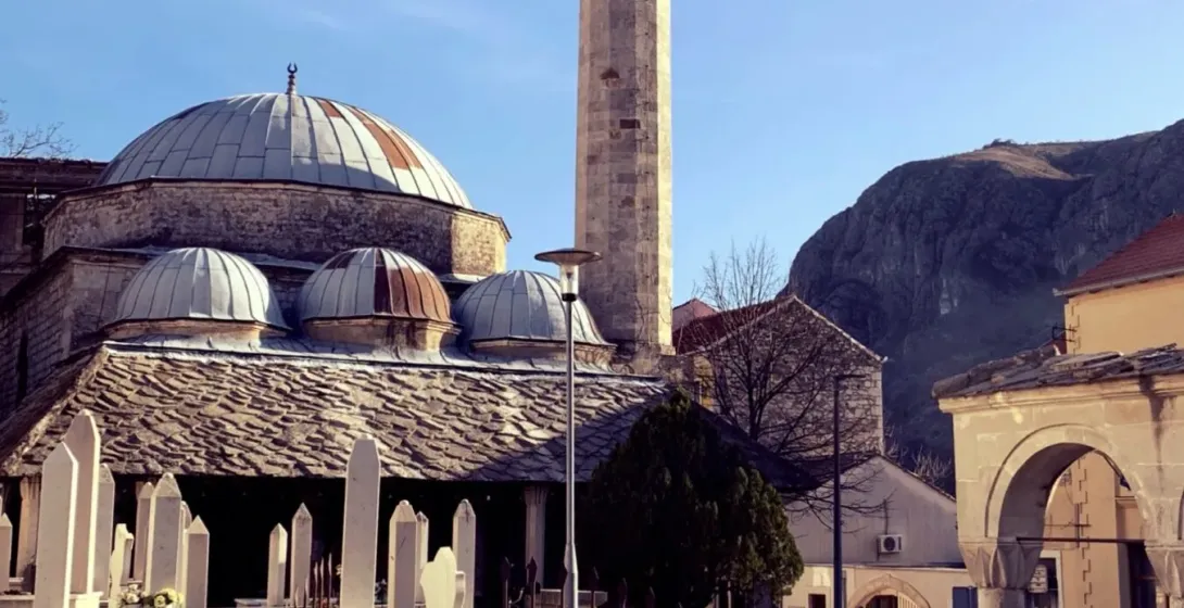 Spokojny meczet w Czarnogórze z wysokim minaretem i spokojnym cmentarzem.