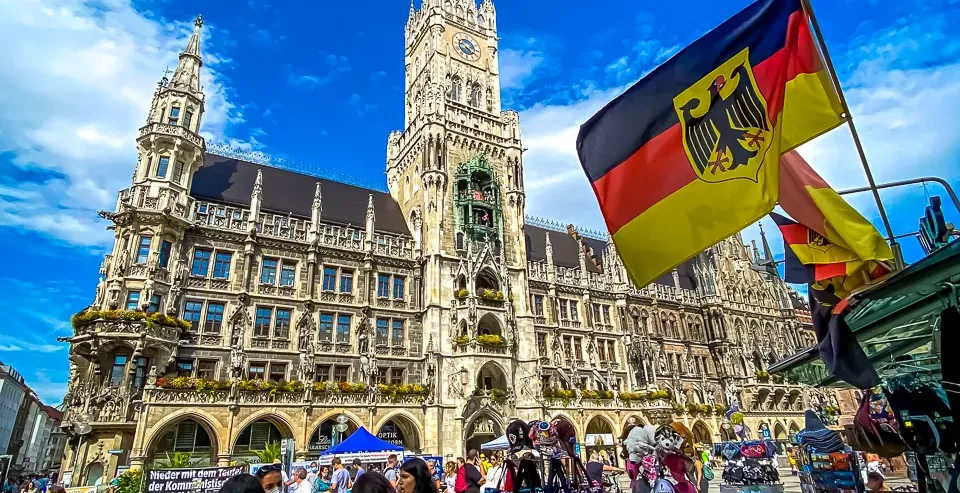 Turyści zwiedzają Marienplatz w Monachium, Niemcy, z nowym ratuszem w tle.