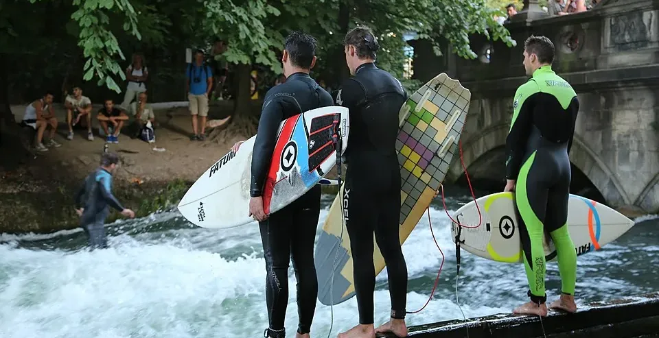 Surferzy przygotowują się do jazdy na fali Eisbach w Monachijskim Ogrodzie Angielskim.