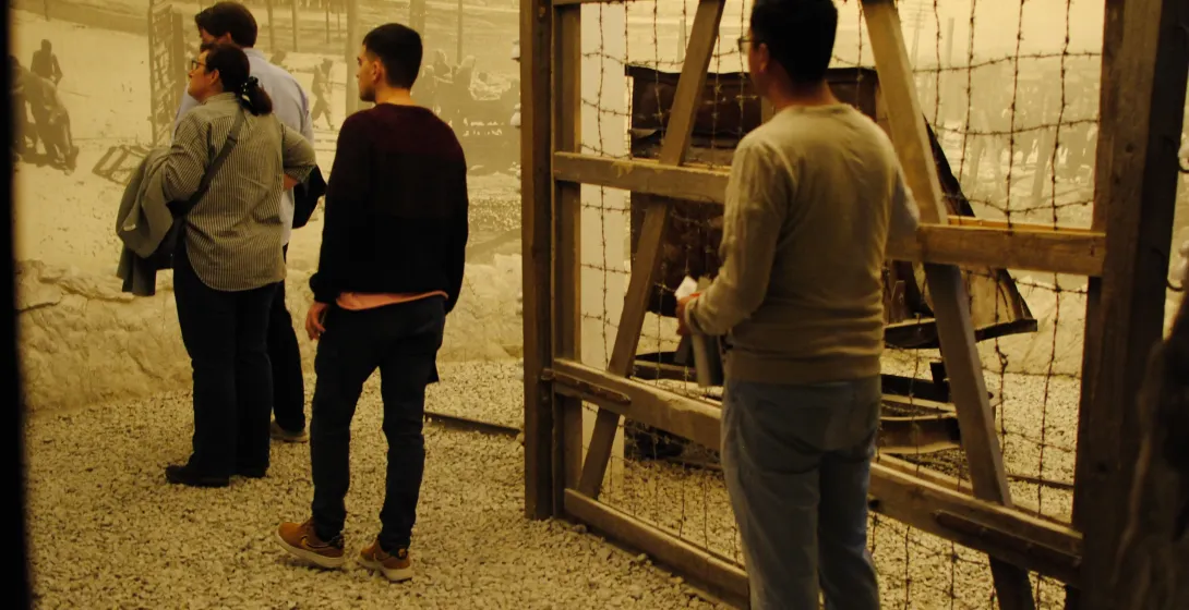 Tourists visiting a somber museum exhibit, reflecting on history.