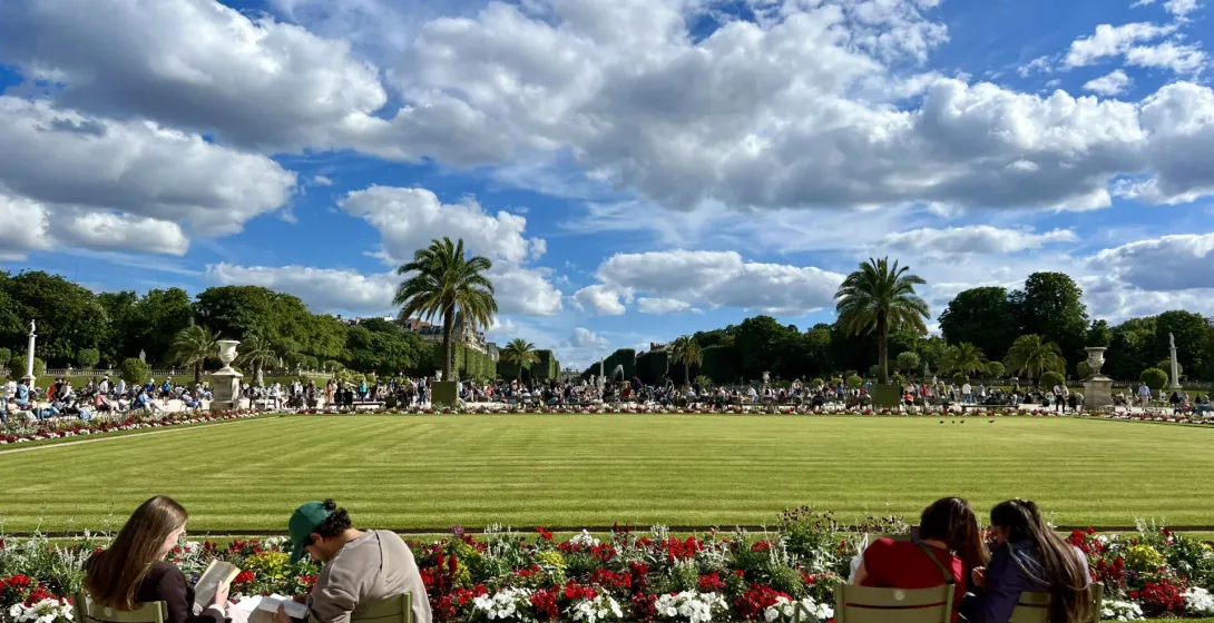 Turistas relajándose en un hermoso jardín parisino.