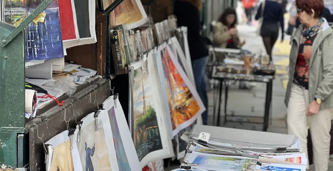 Pinturas coloridas en exhibición en un mercado de arte callejero parisino.