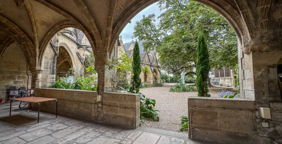 Sereno patio en París, visto a través de antiguos arcos de piedra.