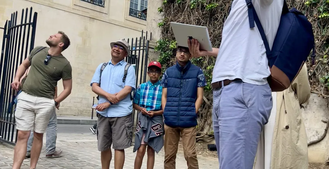 Ein Reiseleiter führt eine Gruppe auf einem Spaziergang durch Paris.