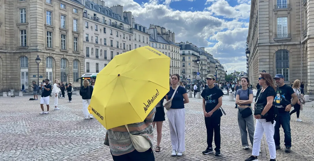 Un guía de Walkative! conduce a un grupo por una plaza parisina.
