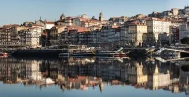 Panoramiczny widok dzielnicy Ribeira w Porto odbijający się w rzece Douro.