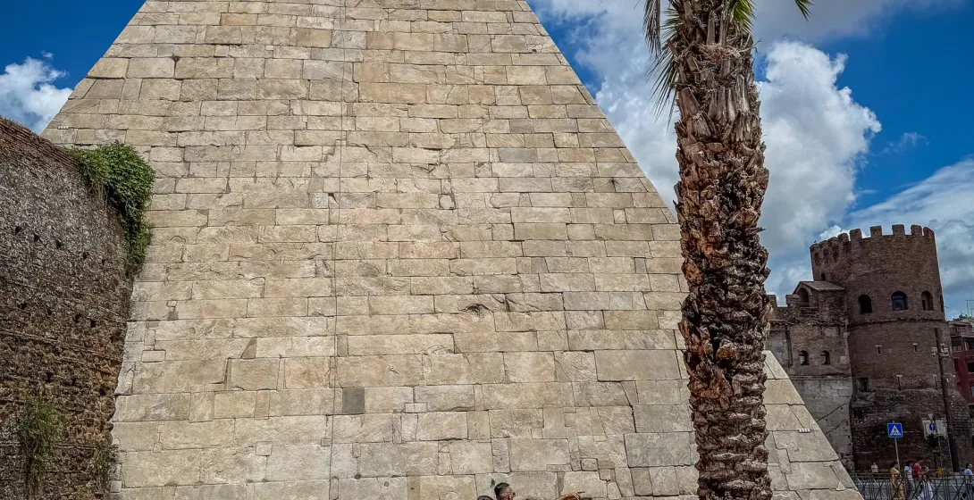 Turistas explorando la Pirámide de Cestio en Roma.